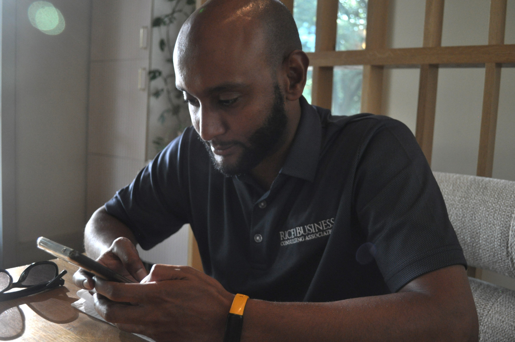 Nebiyu browsing his phone at a coffee shop